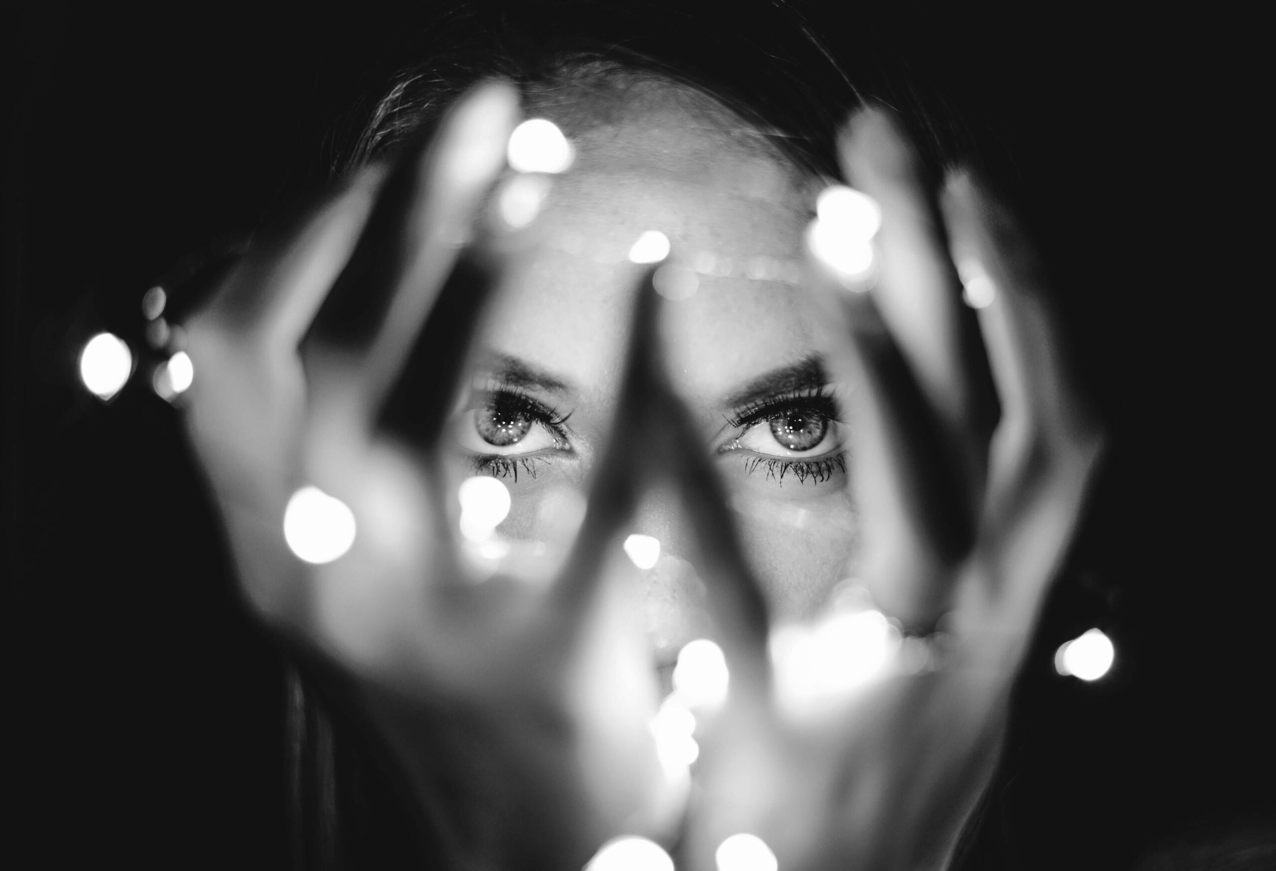 HER energy This is a photo of a woman holding some fairy lights